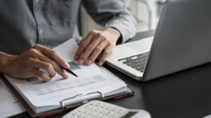 Asian business man holding paper document calculating tax insurance managing budget