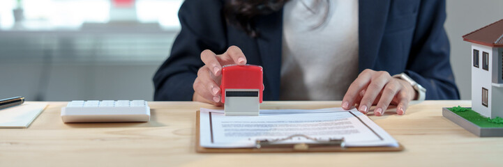 Real estate agent stamping a contract for a new house purchase, finalizing the agreement between...