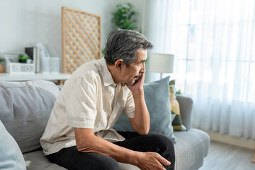 Fototapeta premium Asian senior elderly depress man sitting alone in living room at home. 