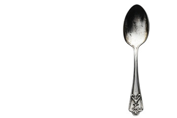 Elegant vintage silver spoon resting against a plain background with intricate detailing on the handle