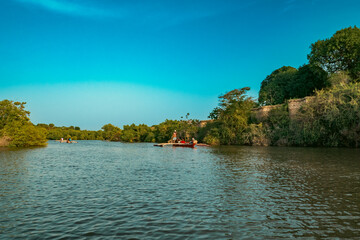 Scenic view of Tourists on a boat at a sunset cruise on the meandering estuary of the Kongo River in Diani, Kenya