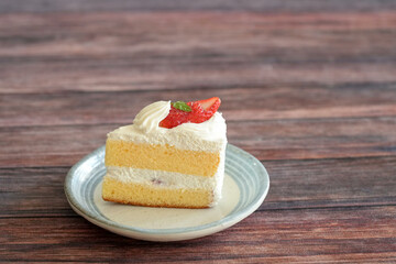 Japanese shortcake with strawberries on top is placed on wooden floor