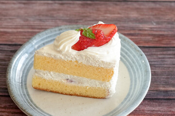 Japanese shortcake with strawberries on top is placed on wooden floor