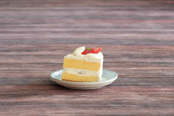 Japanese shortcake with strawberries on top is placed on wooden floor