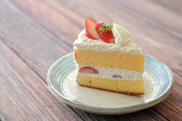 Japanese shortcake with strawberries on top is placed on wooden floor