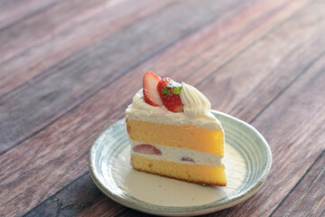 Japanese shortcake with strawberries on top is placed on wooden floor