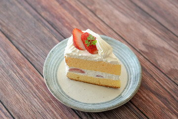 Japanese shortcake with strawberries on top is placed on wooden floor