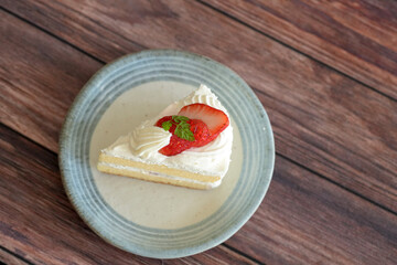 Japanese shortcake with strawberries on top is placed on wooden floor
