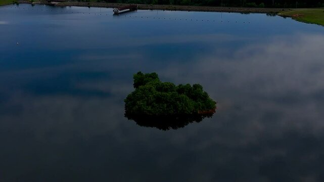 Drone footage of a tiny island off the shore of Lake Mooney at dusk in Fredericksburg, Virginia, USA