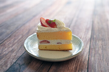 Japanese shortcake with strawberries on top is placed on wooden floor