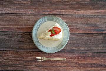 Japanese shortcake with strawberries on top is placed on wooden floor