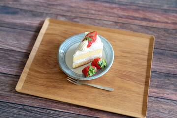Japanese shortcake with strawberries on top is placed on wooden floor