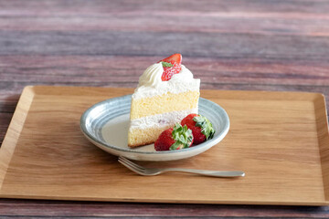 Japanese shortcake with strawberries on top is placed on wooden floor