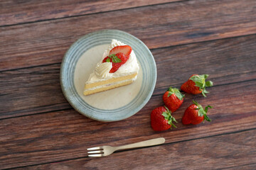 Japanese shortcake with strawberries on top is placed on wooden floor