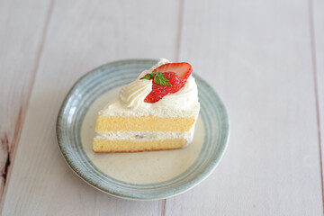 Japanese shortcake with strawberries on top is placed on a white wooden floor