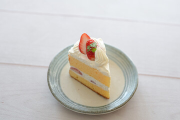 Japanese shortcake with strawberries on top is placed on a white wooden floor