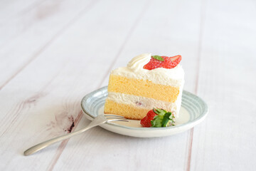 Japanese shortcake with strawberries on top is placed on a white wooden floor