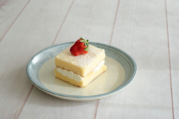 Japanese shortcake with strawberries on top is placed on a white wooden floor