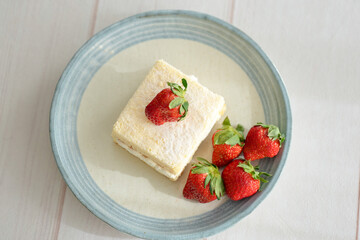 Japanese shortcake with strawberries on top is placed on a white wooden floor