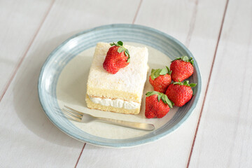 Japanese shortcake with strawberries on top is placed on a white wooden floor