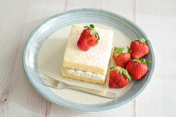 Japanese shortcake with strawberries on top is placed on a white wooden floor
