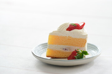 Japanese shortcake with strawberries on top is placed on a white wooden floor