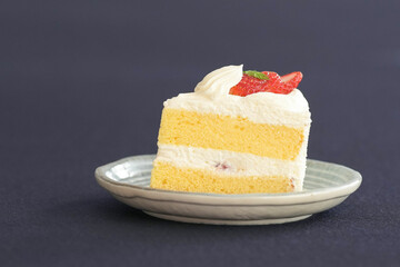 Japanese shortcake with strawberries on top is placed on a black cloth
