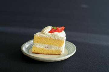 Japanese shortcake with strawberries on top is placed on a black cloth