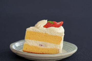 Japanese shortcake with strawberries on top is placed on a black cloth