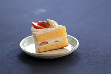 Japanese shortcake with strawberries on top is placed on a black cloth