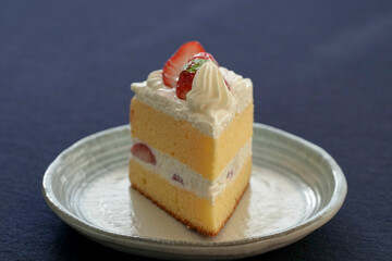 Japanese shortcake with strawberries on top is placed on a black cloth