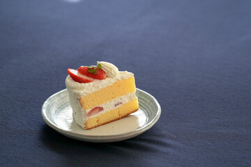 Japanese shortcake with strawberries on top is placed on a black cloth