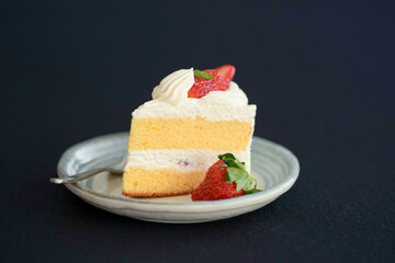 Japanese shortcake with strawberries on top is placed on a black cloth