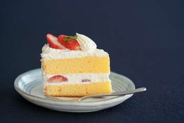 Japanese shortcake with strawberries on top is placed on a black cloth