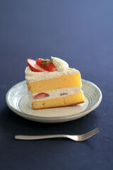 Japanese shortcake with strawberries on top is placed on a black cloth