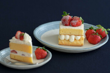Japanese shortcake with strawberries on top is placed on a black cloth
