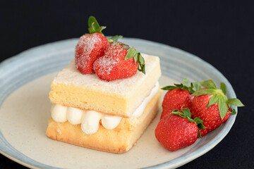 Japanese shortcake with strawberries on top is placed on a black cloth