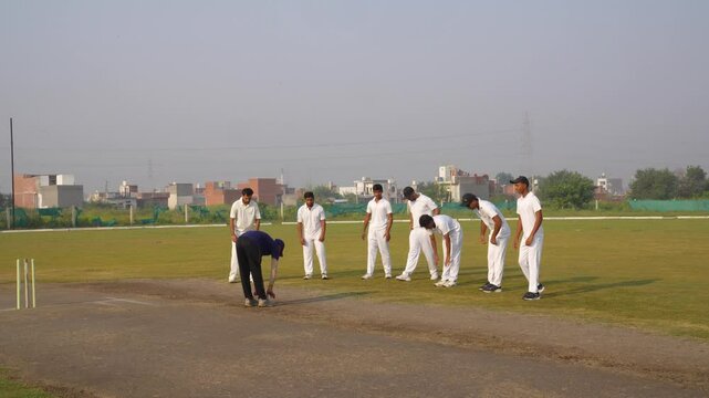 Cricket coach taking warm-up exercises of the team players before the match