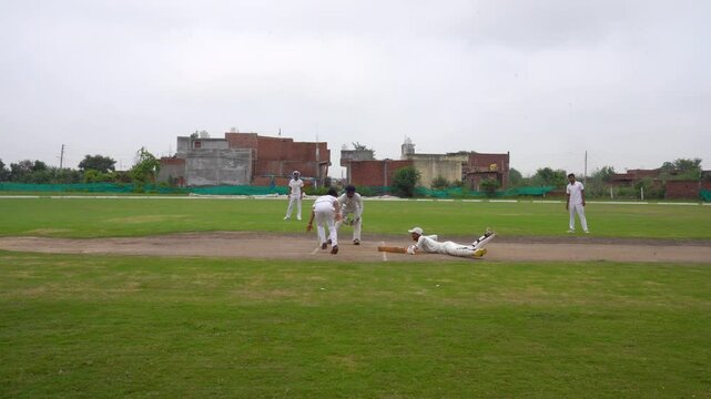Batsman hitting the ball, A Wicket Keeper prepares to run out a Batsman during a match
