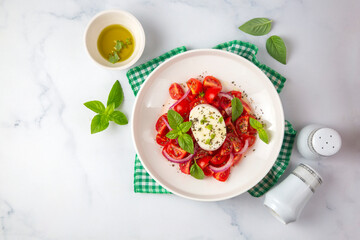 Italian caprese salad with sliced tomatoes, mozzarella, basil, olive oil