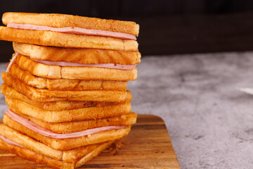 Tasty Ham and Cheese Sandwiches Stacked Vertically on a Concrete Table