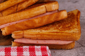 Savory Ham and Cheese Sandwiches Stacked Vertically on a Dark Table