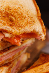 Half-Eaten Egg, Ham, and Cheese Sandwich on a Vertical Tower with Cherry Tomatoes