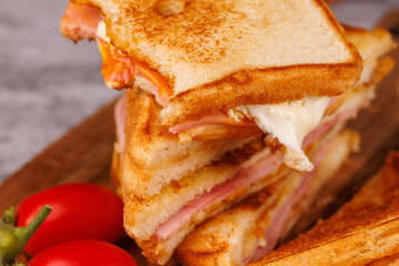 Colorful Egg, Ham, and Cheese Sandwich with Cherry Tomatoes on a Gray Concrete Table