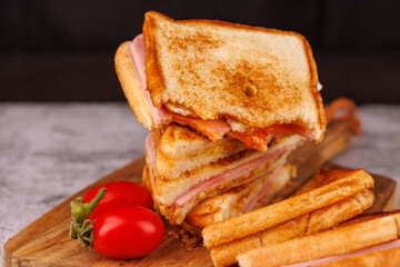 Appetizing Egg, Ham, and Cheese Sandwich Partially Eaten with Cherry Tomatoes
