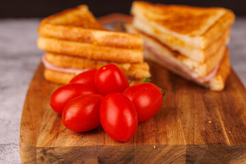 Colorful Ham and Cheese Sandwich with Cherry Tomatoes on a Gray Concrete Surface