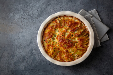 Potato gratin - graten (baked potatoes with cream and cheese) with rosemary and forks (Turkish name; Kremali patates)