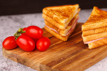 Appetizing Ham and Cheese Sandwich with Cherry Tomatoes on a Gray Table