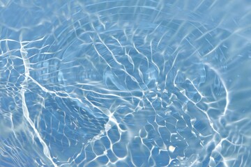 Bluewater waves on the surface ripples blurred. Defocus blurred transparent blue colored clear calm water surface texture with splash and bubbles. Water waves with shining pattern texture background.