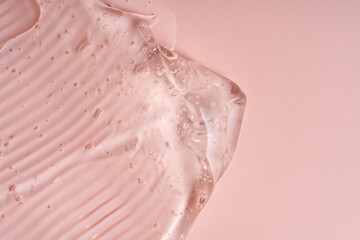 Liquid gel abstract cosmetic in pink background. Smear of transparent moisturizing product